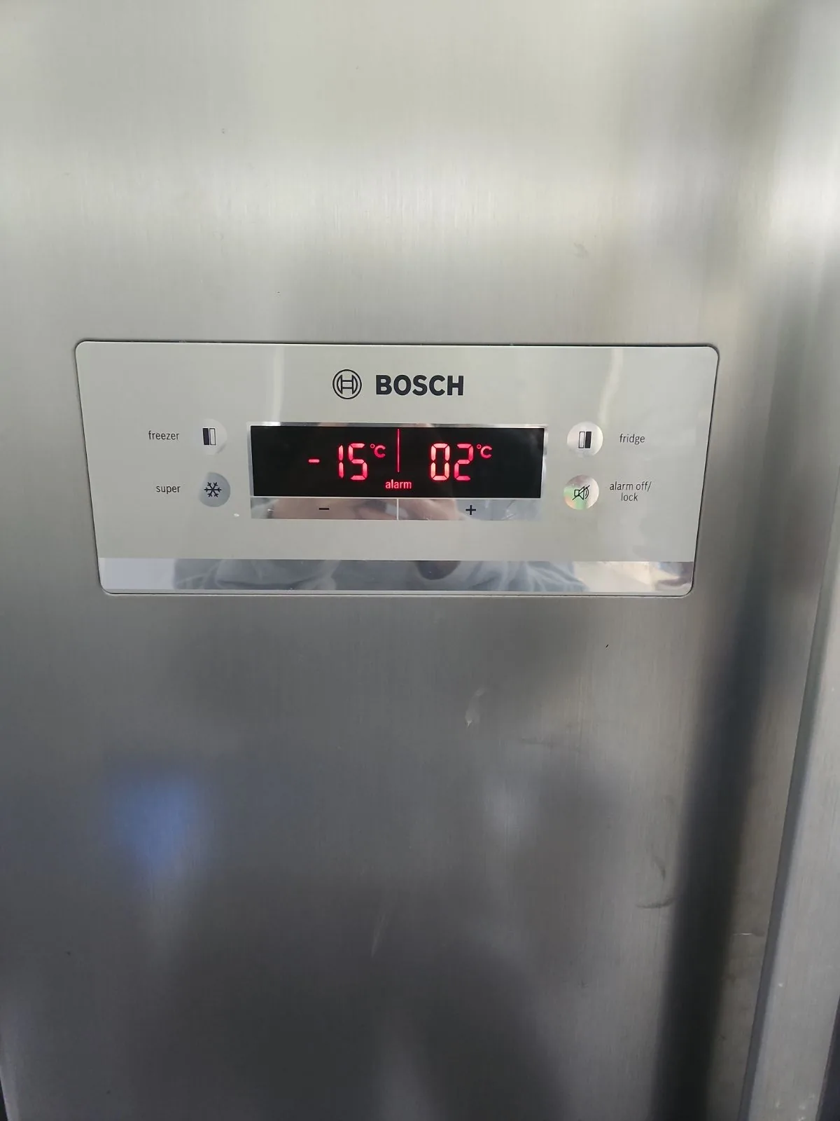 Refrigerator control panel showing a temperature warning