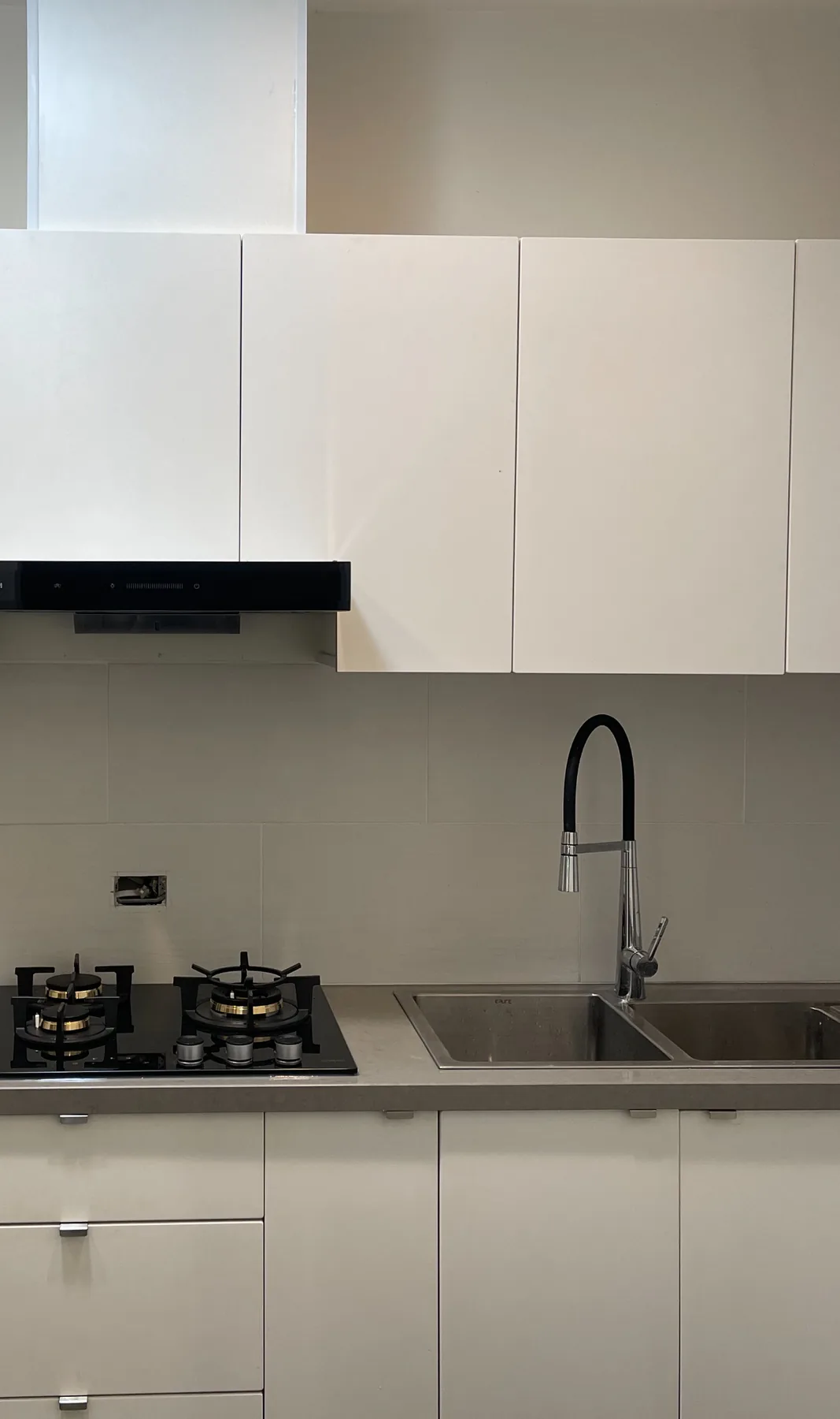 Installed black rangehood above a kitchen cooktop