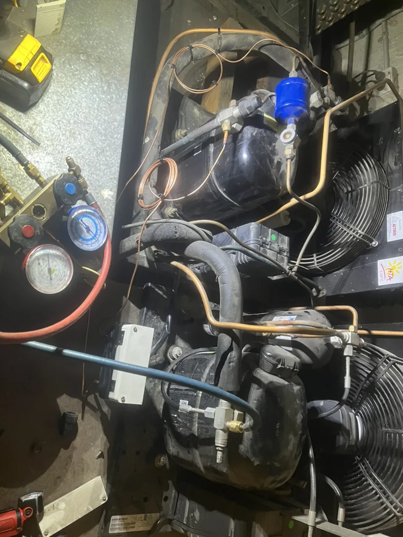 Refrigeration service gauges connected near compressor pipework